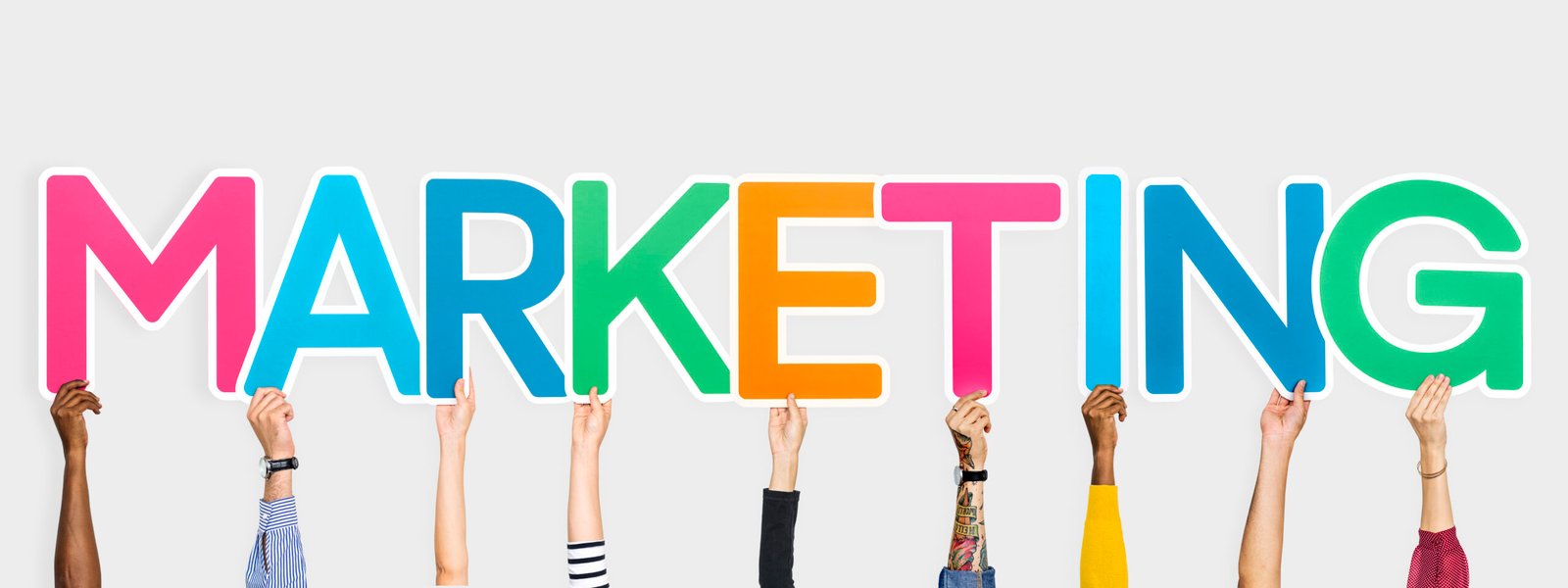 Hands holding up colorful letters forming the word marketing marketinga